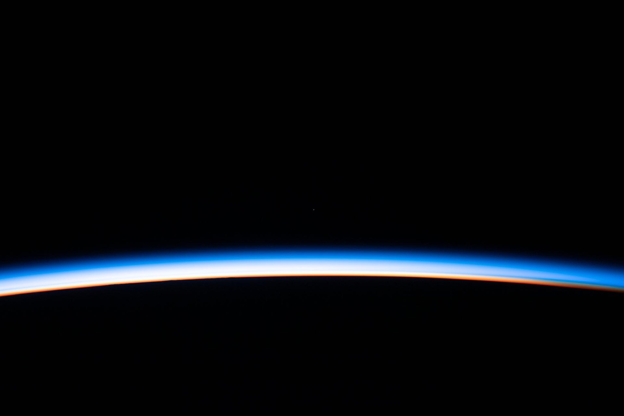 A thin band of sunlit atmosphere along Earth's dark horizon